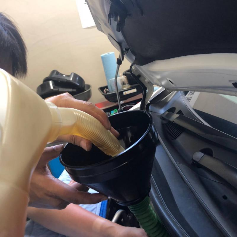 フィラーキャップがエンジンルームの奥にあるので、先の長いジョウゴを使って新油を入れていきます。